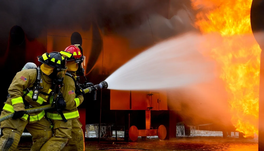 Brandmän genomför släckning av brand under praktisk brandövning